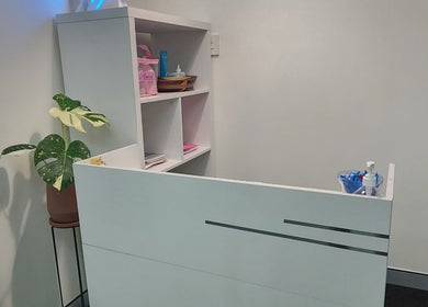 Reception desk at G'Day Massage Perth, Perth, Western Australia, AU with modern decor and potted plant.