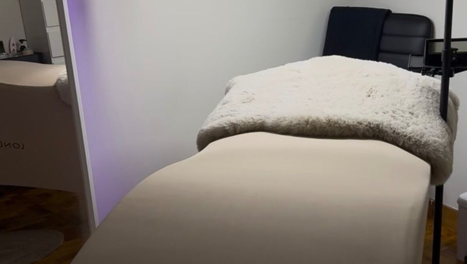 Cama de tratamiento en Glowwstudiio, Oviedo, ES, con manta blanca adicional para máxima comodidad.