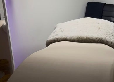 Cama de tratamiento en Glowwstudiio, Oviedo, ES, con manta blanca adicional para máxima comodidad.