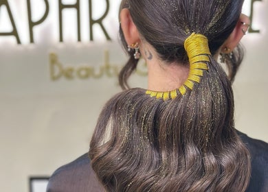 Stylish ponytail with gold accents at Aphrodite Beauty & Spa, Abu Dhabi, AE.