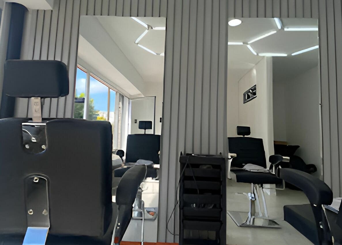 Interior moderno de REGIOS BARBERIA en Quilmes, Provincia De Buenos Aires, AR con sillas y espejos elegantes.