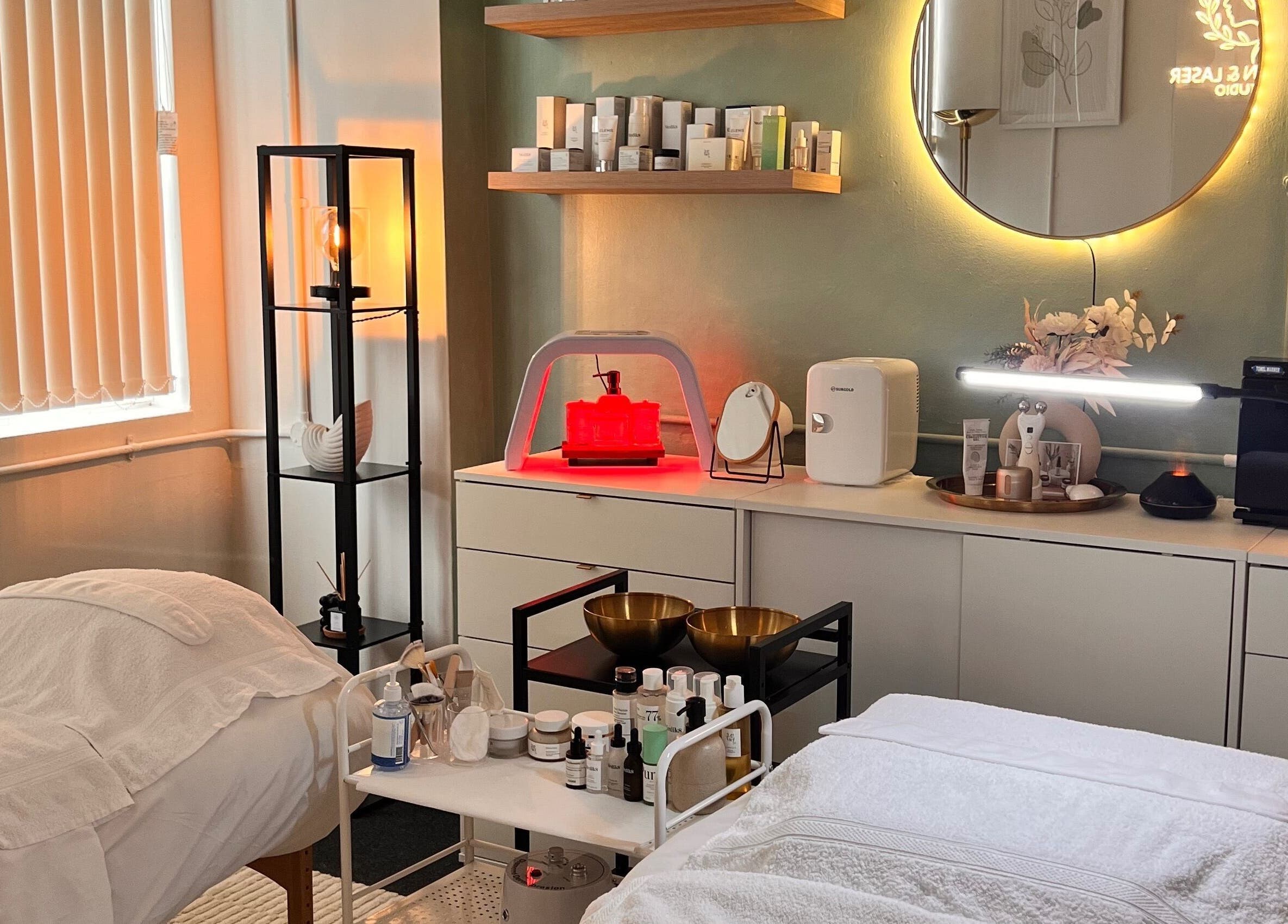 Cozy treatment room at Misskin & Laser Studio, Birmingham, England, GB features ambient lighting and skincare products.