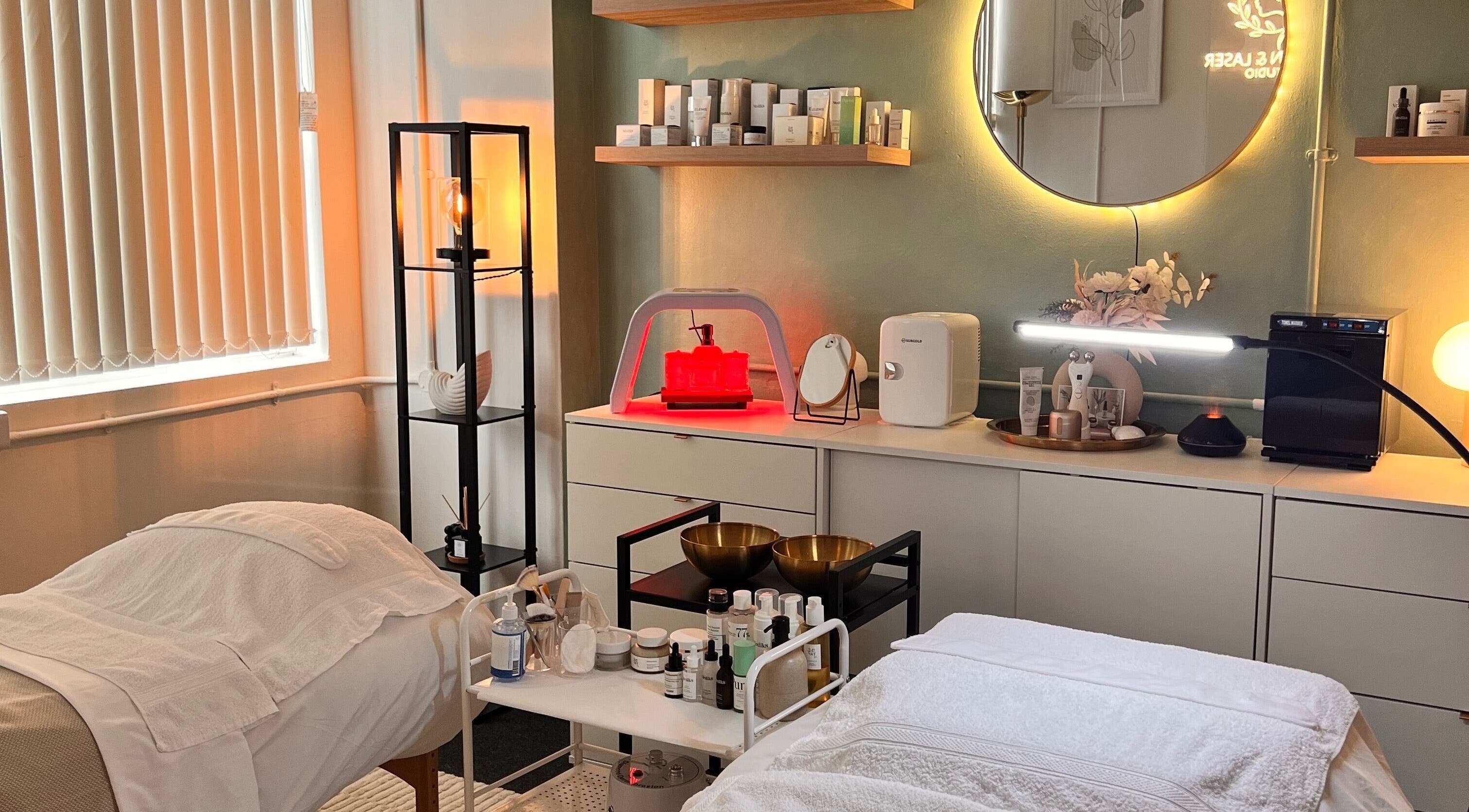 Cozy treatment room at Misskin & Laser Studio, Birmingham, England, GB features ambient lighting and skincare products.