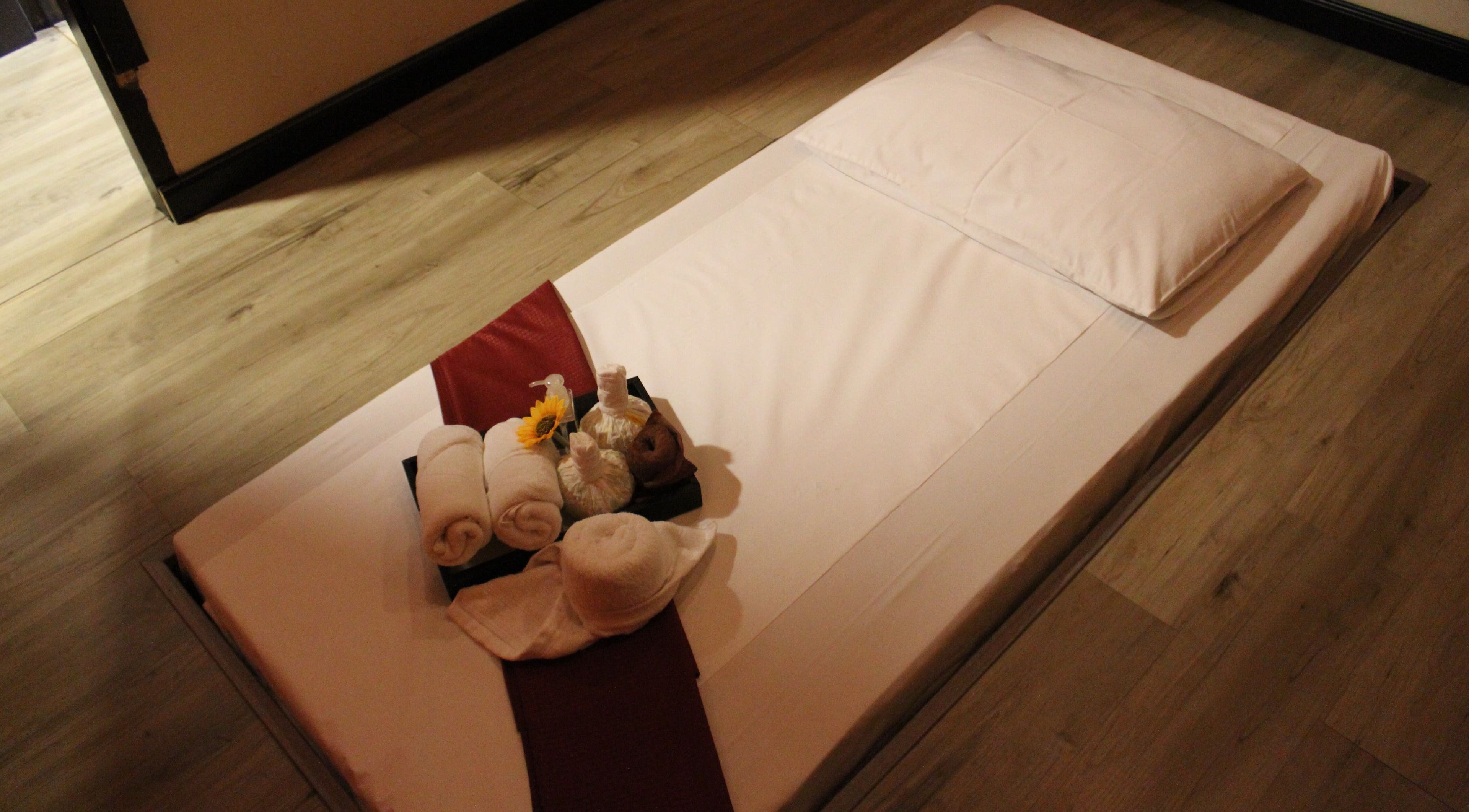 Relaxing spa setup at Feet Lounge Reflexology & Spa - Bay Avenue Mall, دبي, دبي, AE, featuring towels and flowers.