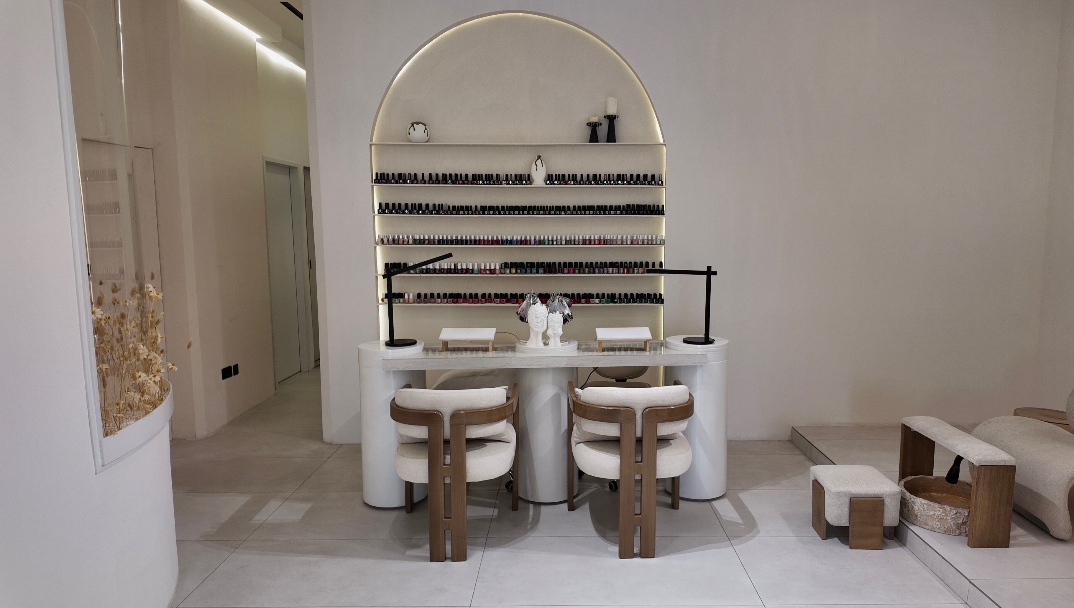 Modern nail lounge at Rare Spa, Sharjah, AE with minimalist decor and extensive nail product display.