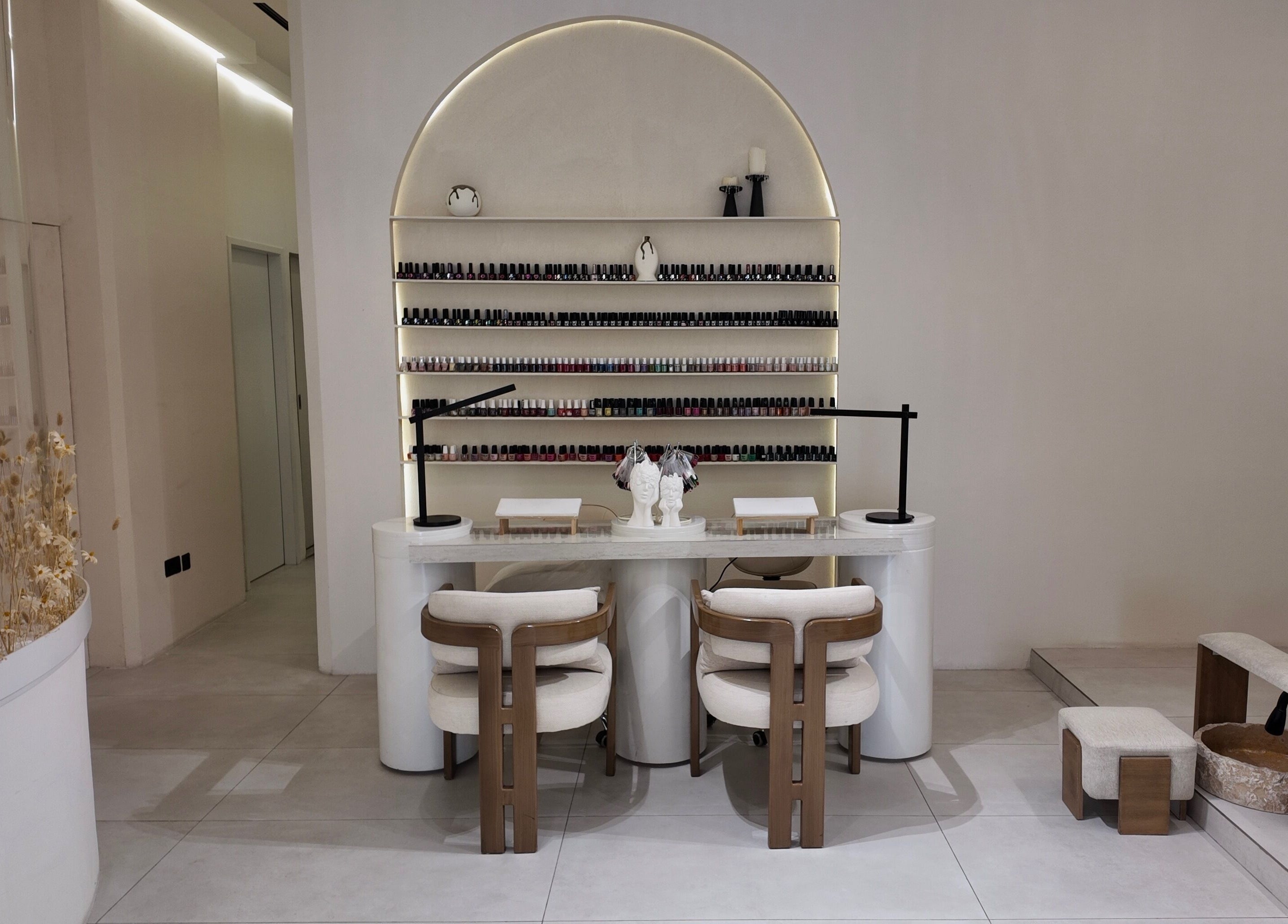 Modern nail lounge at Rare Spa, Sharjah, AE with minimalist decor and extensive nail product display.