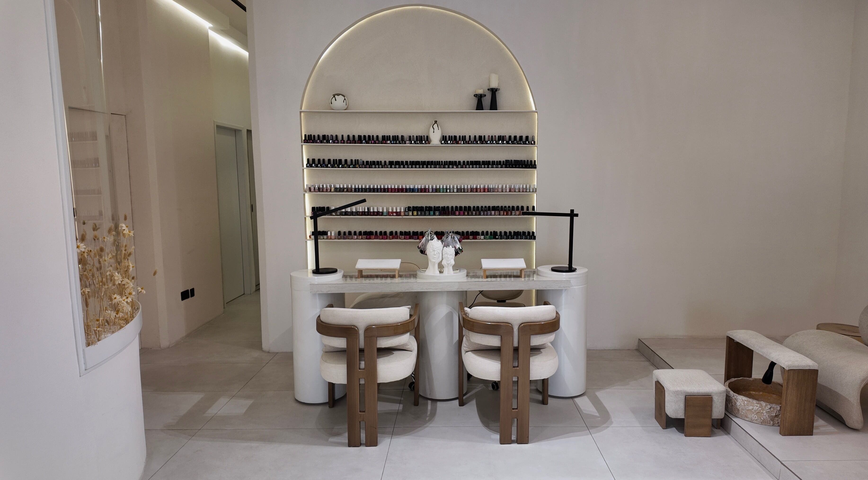 Modern nail lounge at Rare Spa, Sharjah, AE with minimalist decor and extensive nail product display.