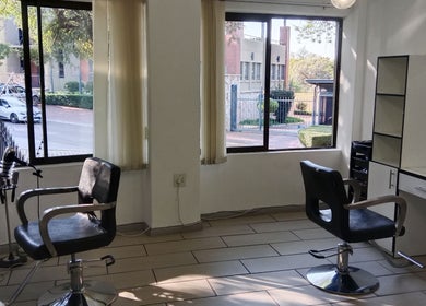Bright salon interior at Tylaz Hair Studio, Randburg, Gauteng, ZA showcasing stylish chairs and large windows.
