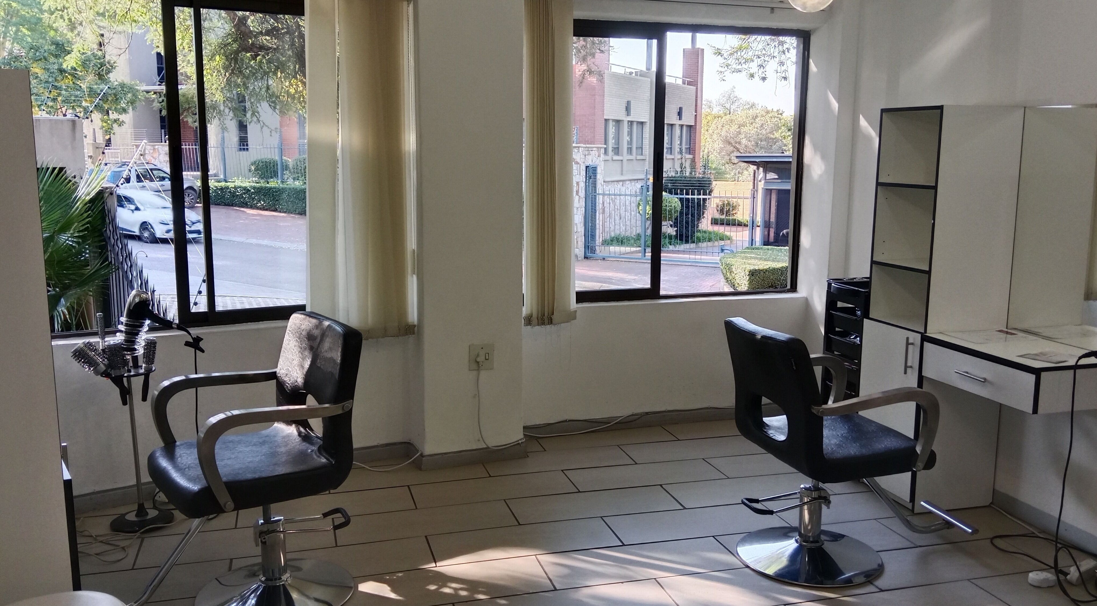 Bright salon interior at Tylaz Hair Studio, Randburg, Gauteng, ZA showcasing stylish chairs and large windows.