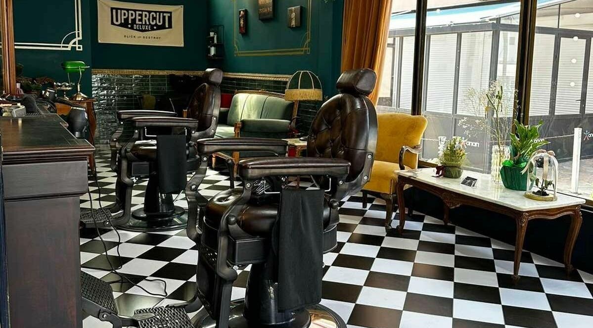 Εσωτερικό Tzovanis Barbershop στο Αχαρνές, κοκκινος μυλος, GR, με κλασικές δερμάτινες καρέκλες και κομψή διακόσμηση.