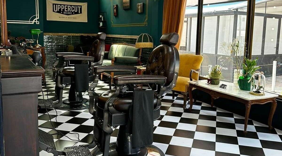 Εσωτερικό Tzovanis Barbershop στο Αχαρνές, κοκκινος μυλος, GR, με κλασικές δερμάτινες καρέκλες και κομψή διακόσμηση.