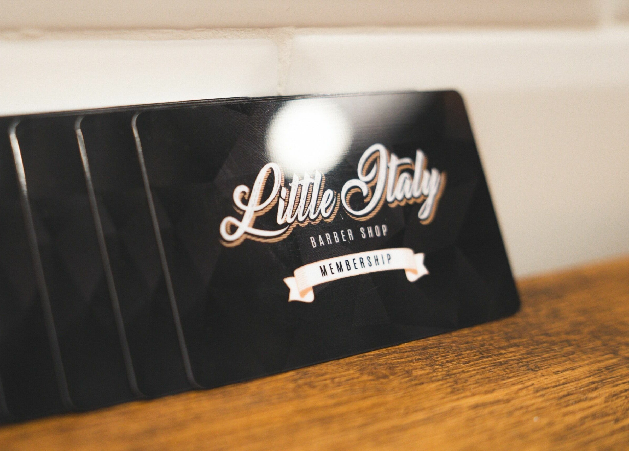 Tessera Modena Cc Grandemilia Little Italy Barbershop su tavolo in legno, Modena, Emilia-romagna, IT.