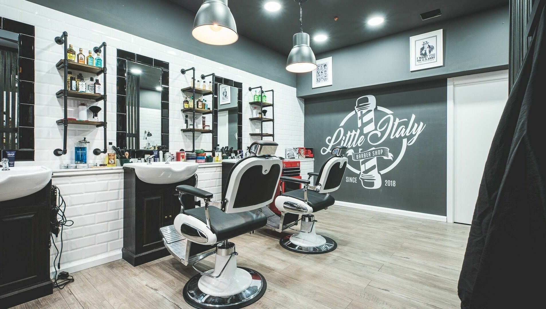 Interno di Little Italy Barbershop a Thiene, Veneto, IT con poltrone eleganti e atmosfera moderna.