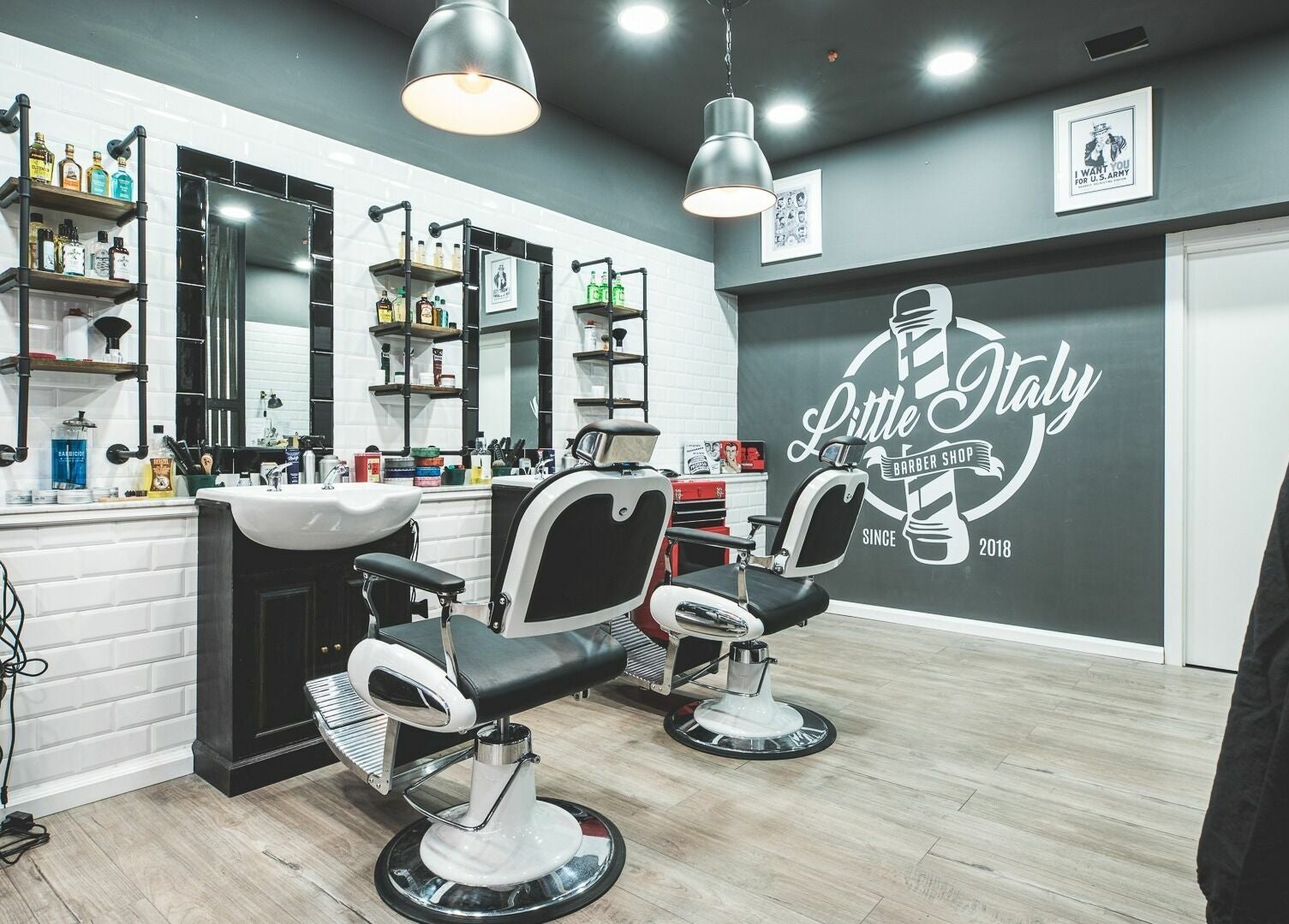 Interno di Little Italy Barbershop a Thiene, Veneto, IT con poltrone eleganti e atmosfera moderna.