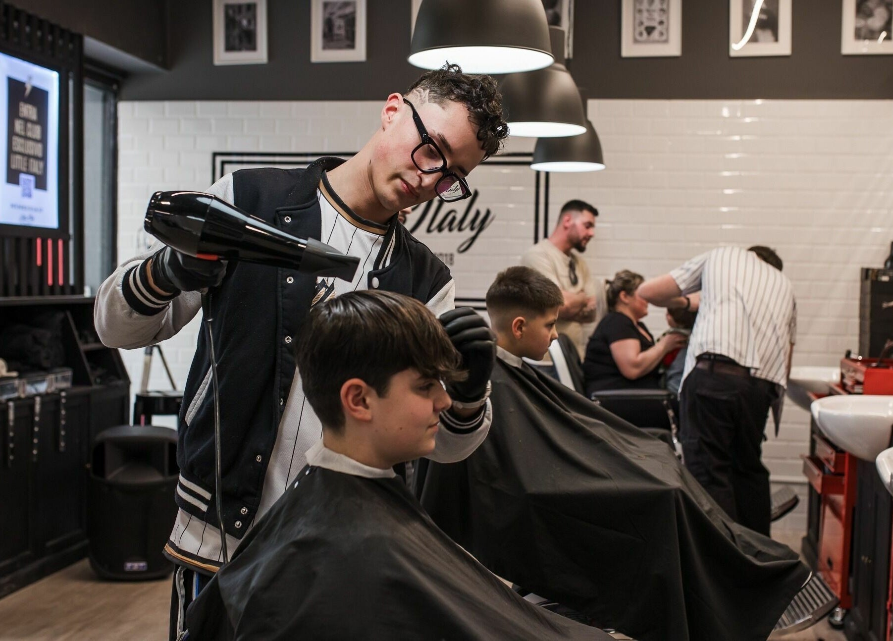 Barbiere professionale al Little Italy Barbershop, Thiene - IperTosano, Thiene, Veneto, IT, cura i capelli di un cliente.