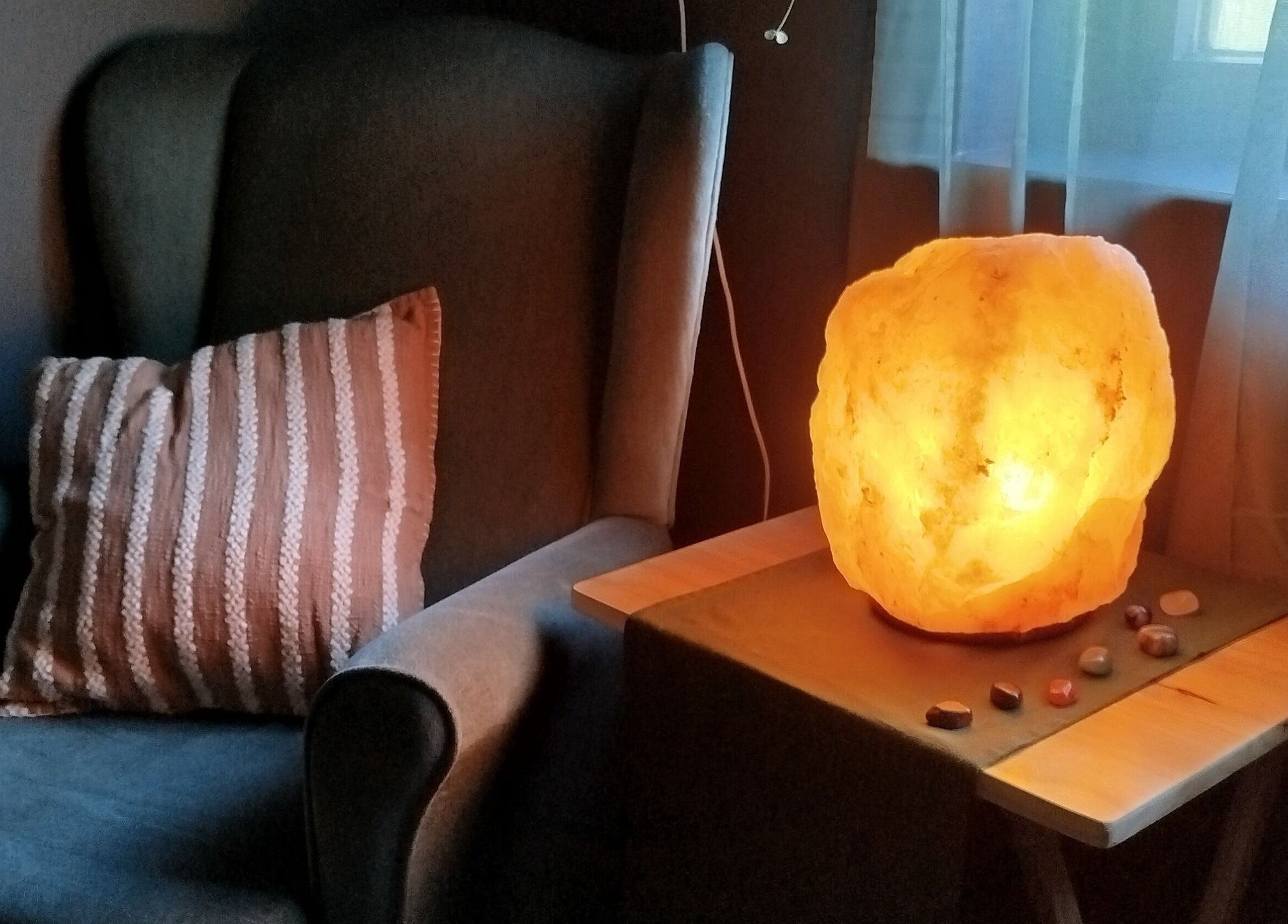 Warm, glowing salt lamp beside a comfy chair at Clare Carson Reflexology at The Luma Practice in Salford, England, GB.