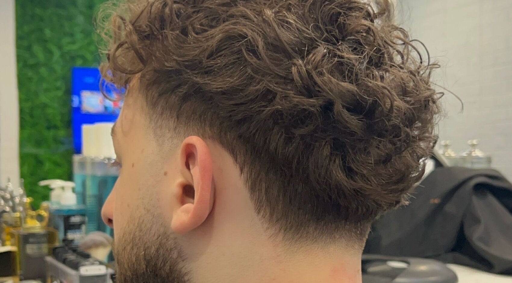 Curly hairstyle with fade at Fade Arcade, Sydenham, New South Wales, AU. Perfect blend for modern looks.