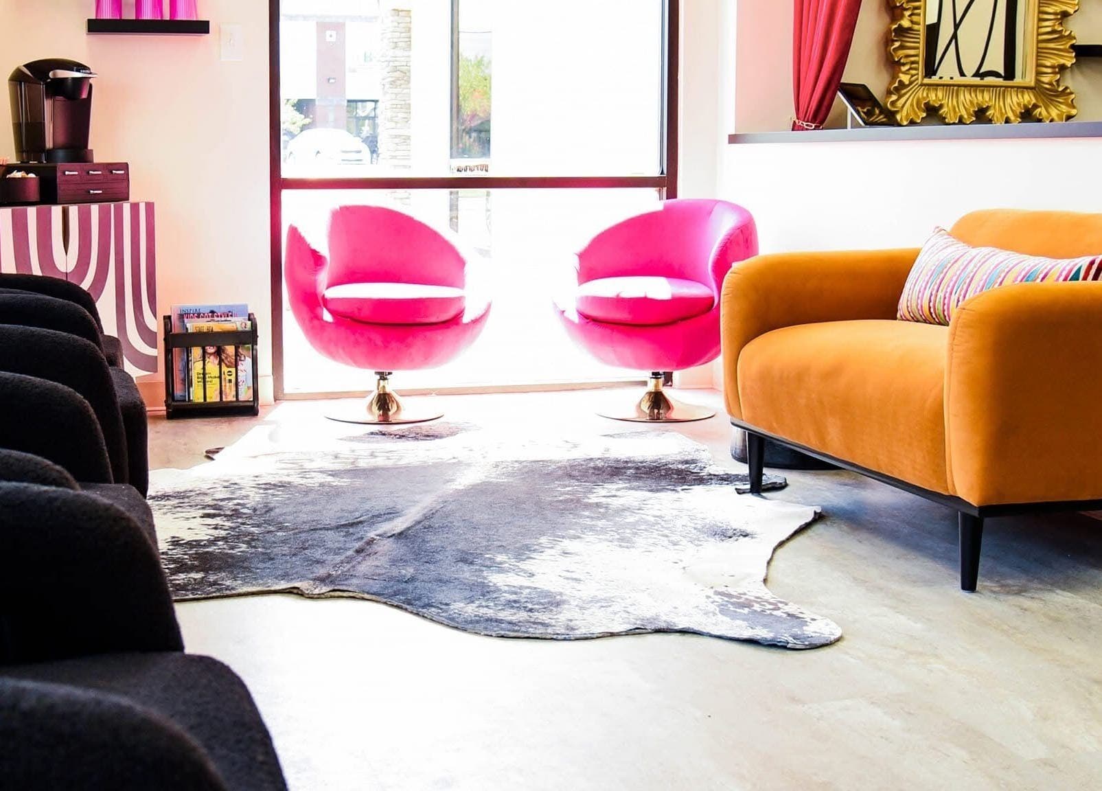 Chic lounge area at M. Curl at Tangles Salon, Springfield, Missouri, US. Features bold furniture and vibrant decor.