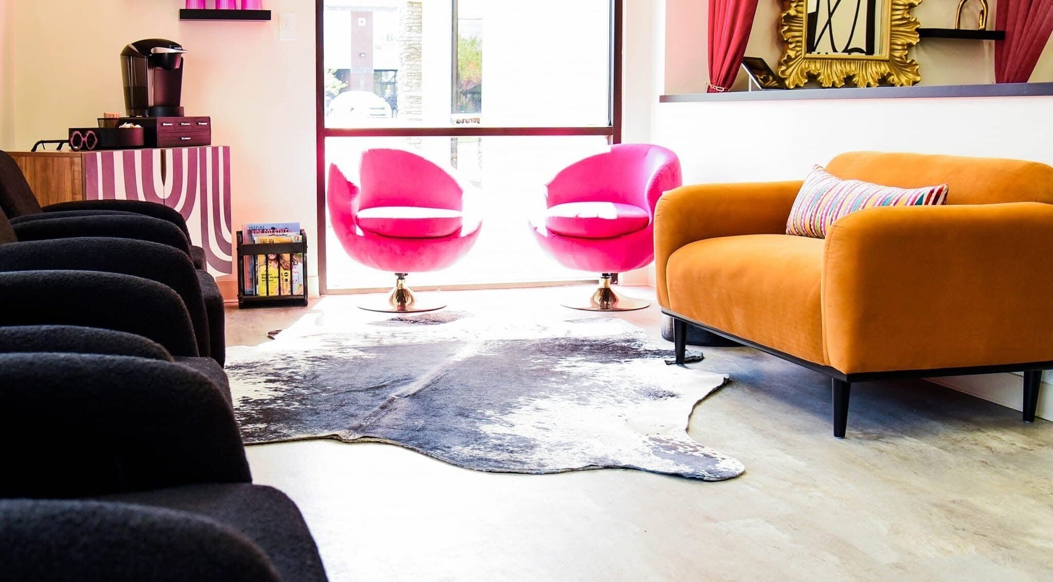 Chic lounge area at M. Curl at Tangles Salon, Springfield, Missouri, US. Features bold furniture and vibrant decor.