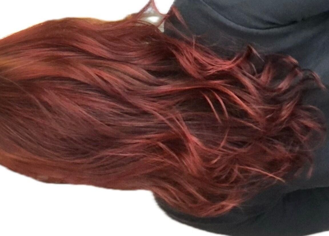 Rich red curls styled at M. Curl at Tangles Salon, Springfield, Missouri, US showcasing vibrant color.