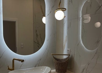 Luxusní koupelna v WellBe, Hlavní Město Praha, CZ s moderním osvětleným zrcadlem a stylovým umyvadlem.