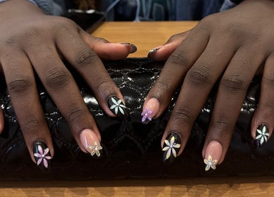 Detailed floral nail art at Studio Rae, Aberdeen, Scotland, GB, showcasing intricate designs on a black clutch.