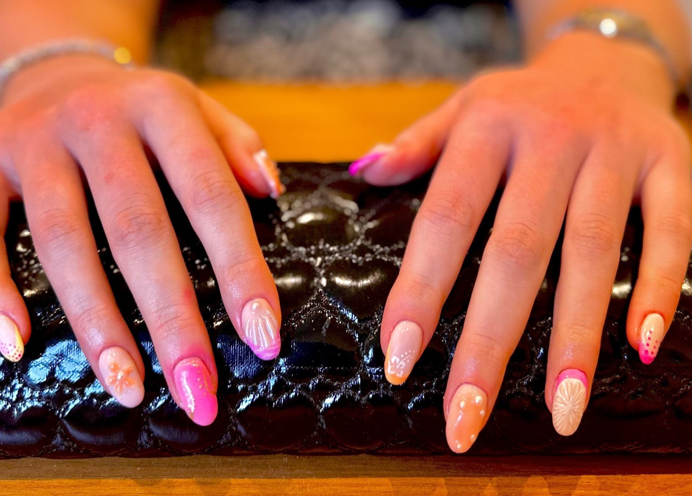 Beautifully designed nails at Studio Rae in Aberdeen, Scotland, GB showcasing intricate nail art on a black cushion.