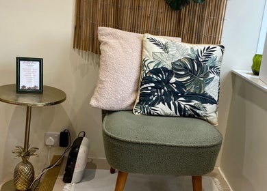 Cozy seating at Flamingo Nails, Park Gate, England, featuring tropical cushions and a chic gold table.