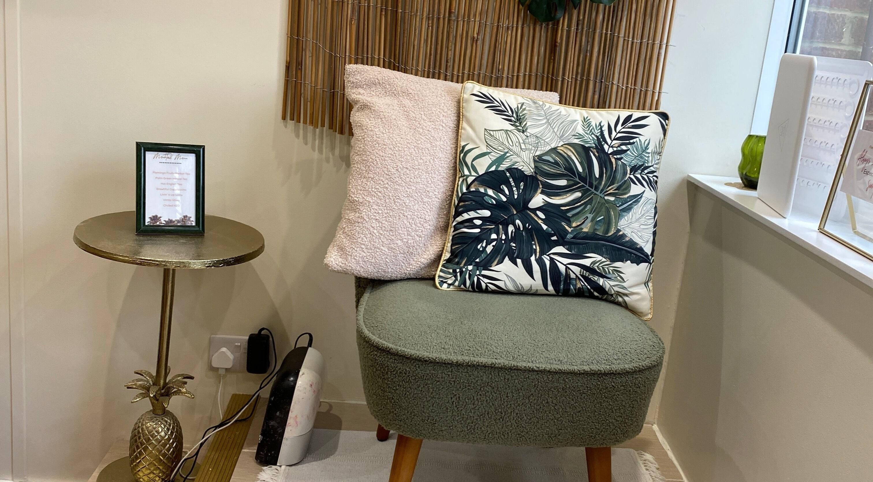 Cozy seating at Flamingo Nails, Park Gate, England, featuring tropical cushions and a chic gold table.