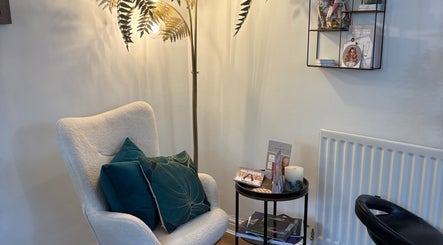 Cozy corner at The Vine Hair by Georgia in Solihull, England, GB, featuring a plush chair and reading materials.