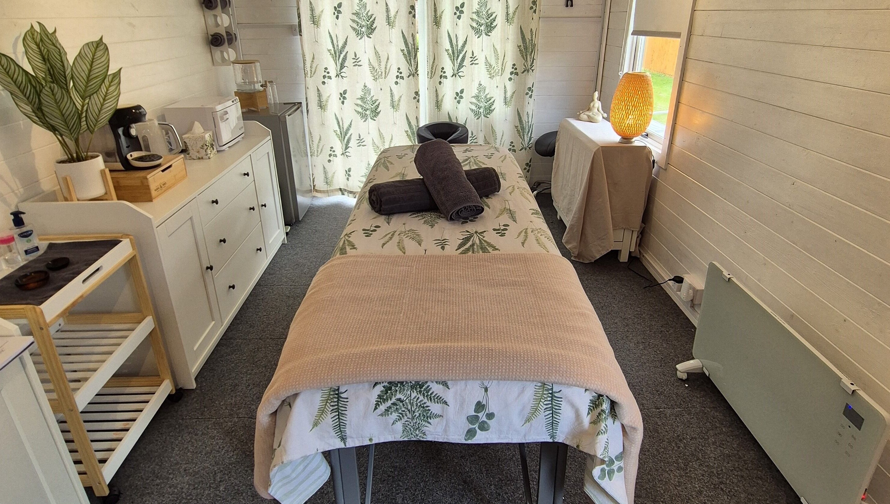 Cozy massage room at Calathea Holistic Health and Wellness, Wimborne, England, GB with warm decor and relaxing ambiance.