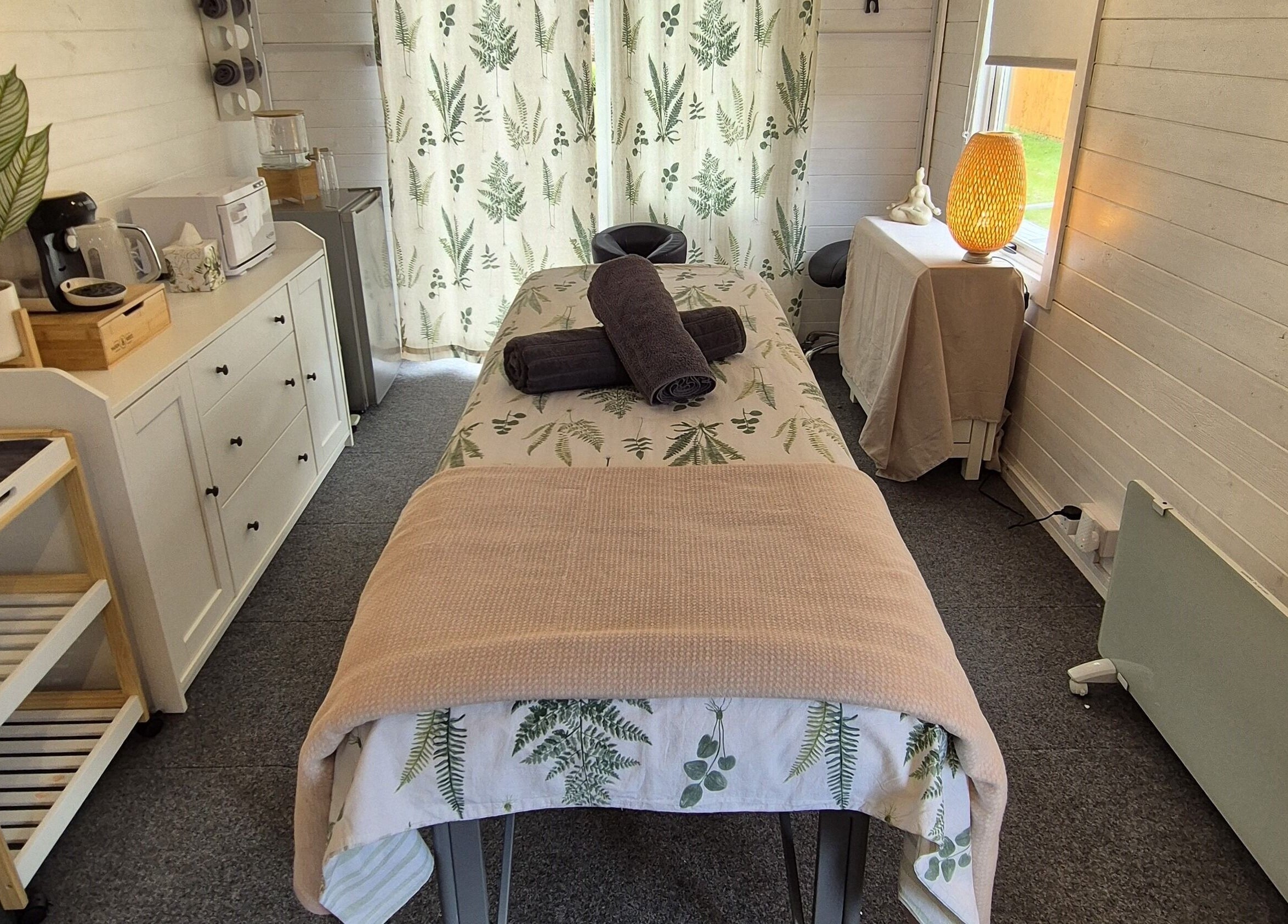 Cozy massage room at Calathea Holistic Health and Wellness, Wimborne, England, GB with warm decor and relaxing ambiance.