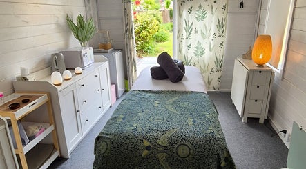 Relaxing massage room at Calathea Holistic Health and Wellness, Wimborne, England, GB, featuring serene decor.