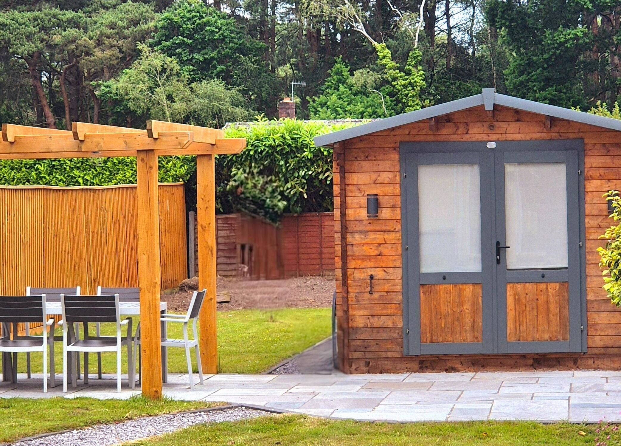 Charming wooden cabin at Calathea Holistic Health and Wellness, Wimborne, England, GB, amidst lush greenery.