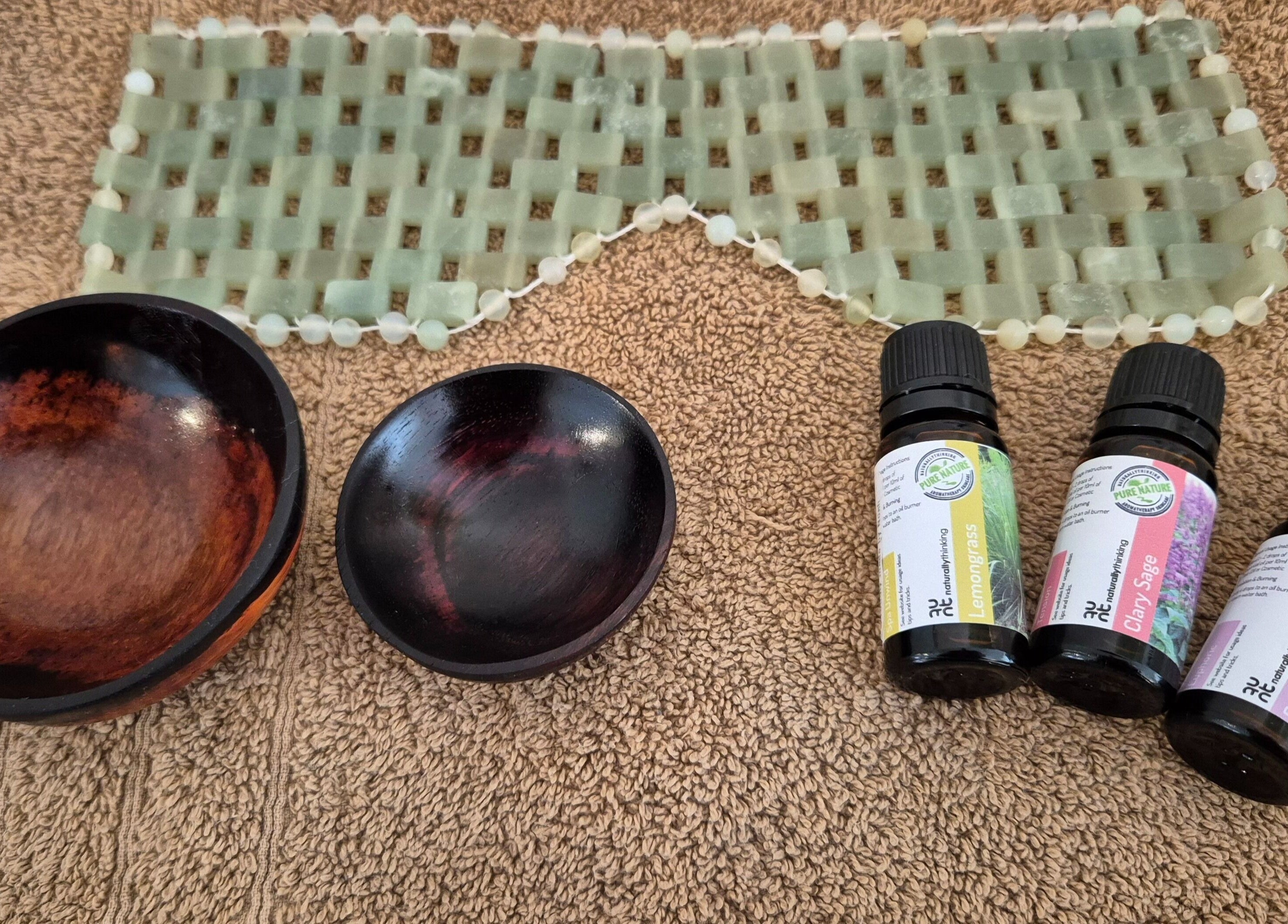 Calathea Holistic Health and Wellness in Wimborne, England, showcases essential oils and bowls on a textured towel.