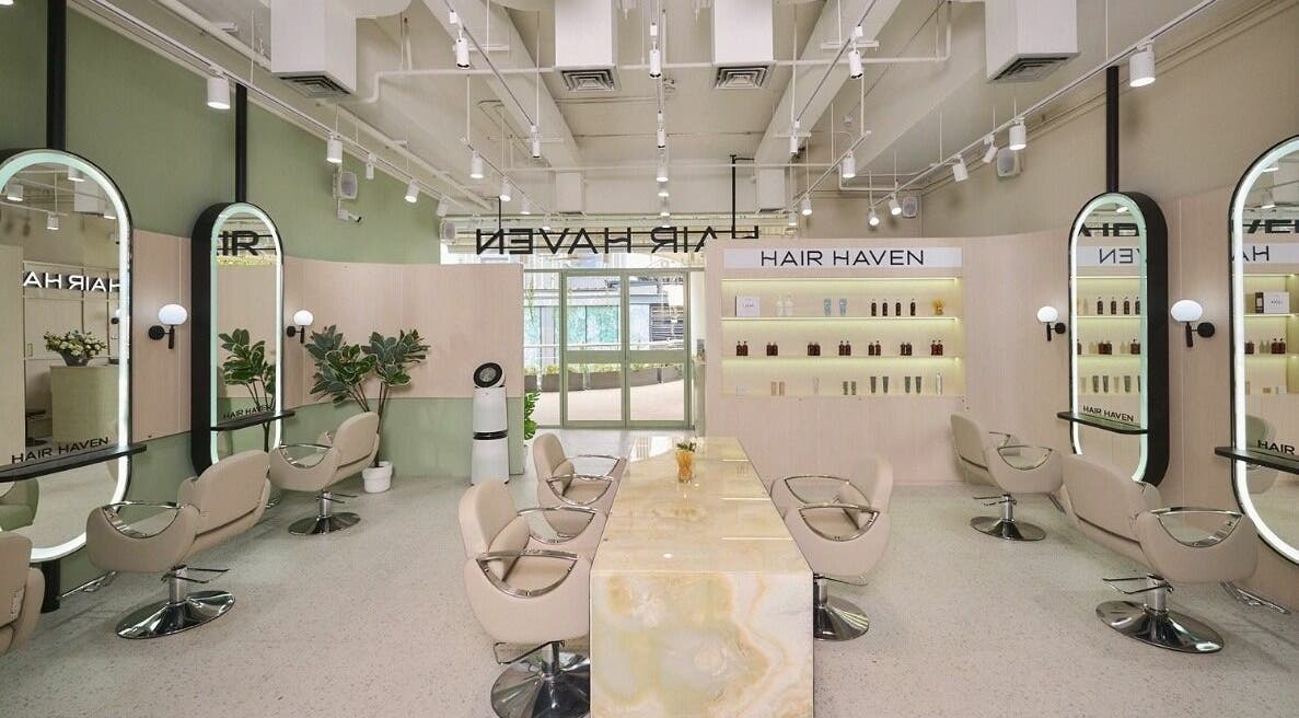 Bright, stylish interior of HAIR HAVEN in กรุงเทพมหานคร, featuring modern chairs and elegant mirrors.