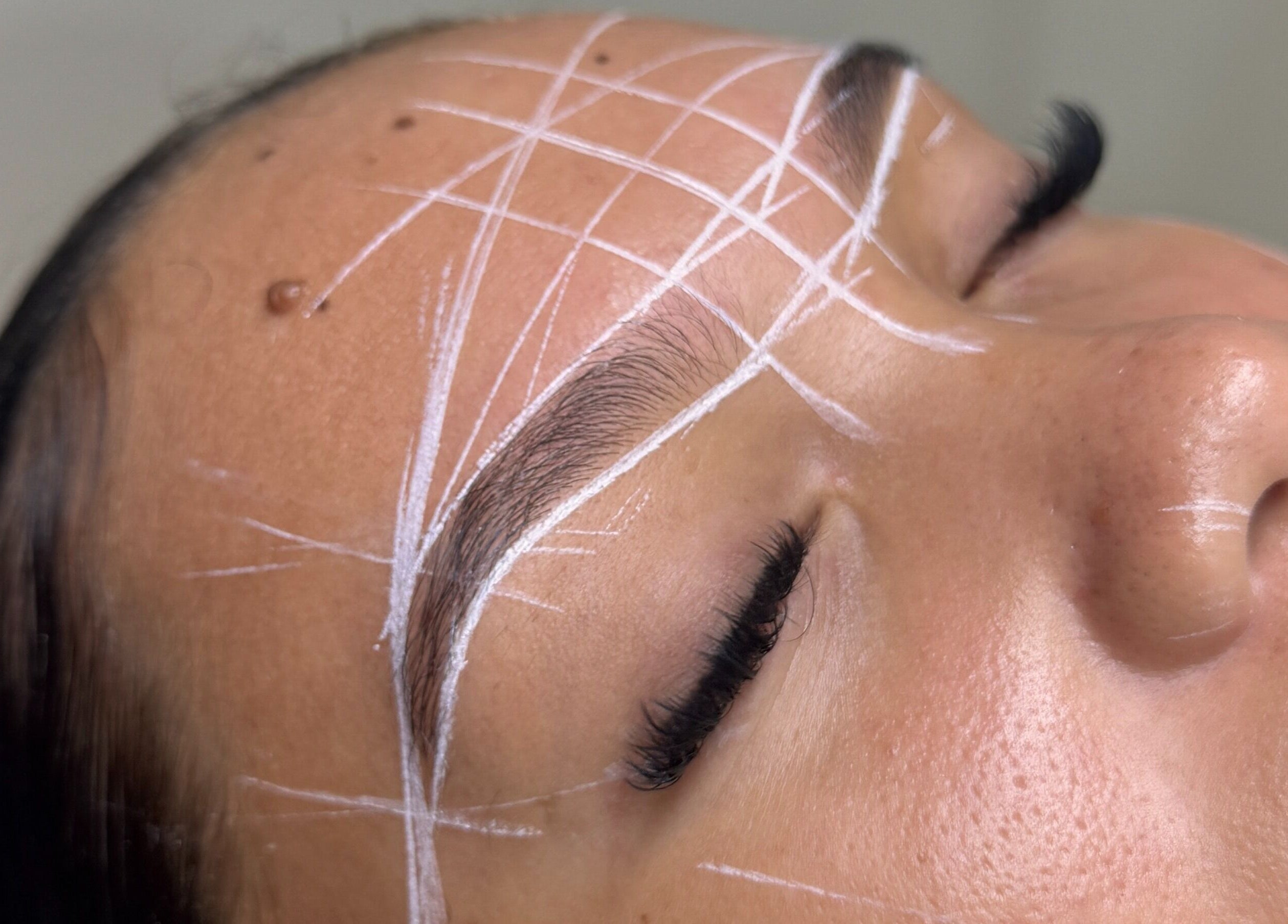Precision brow shaping at Santoriam, Willemstad, Curaçao, CW showcasing detailed white guide lines.