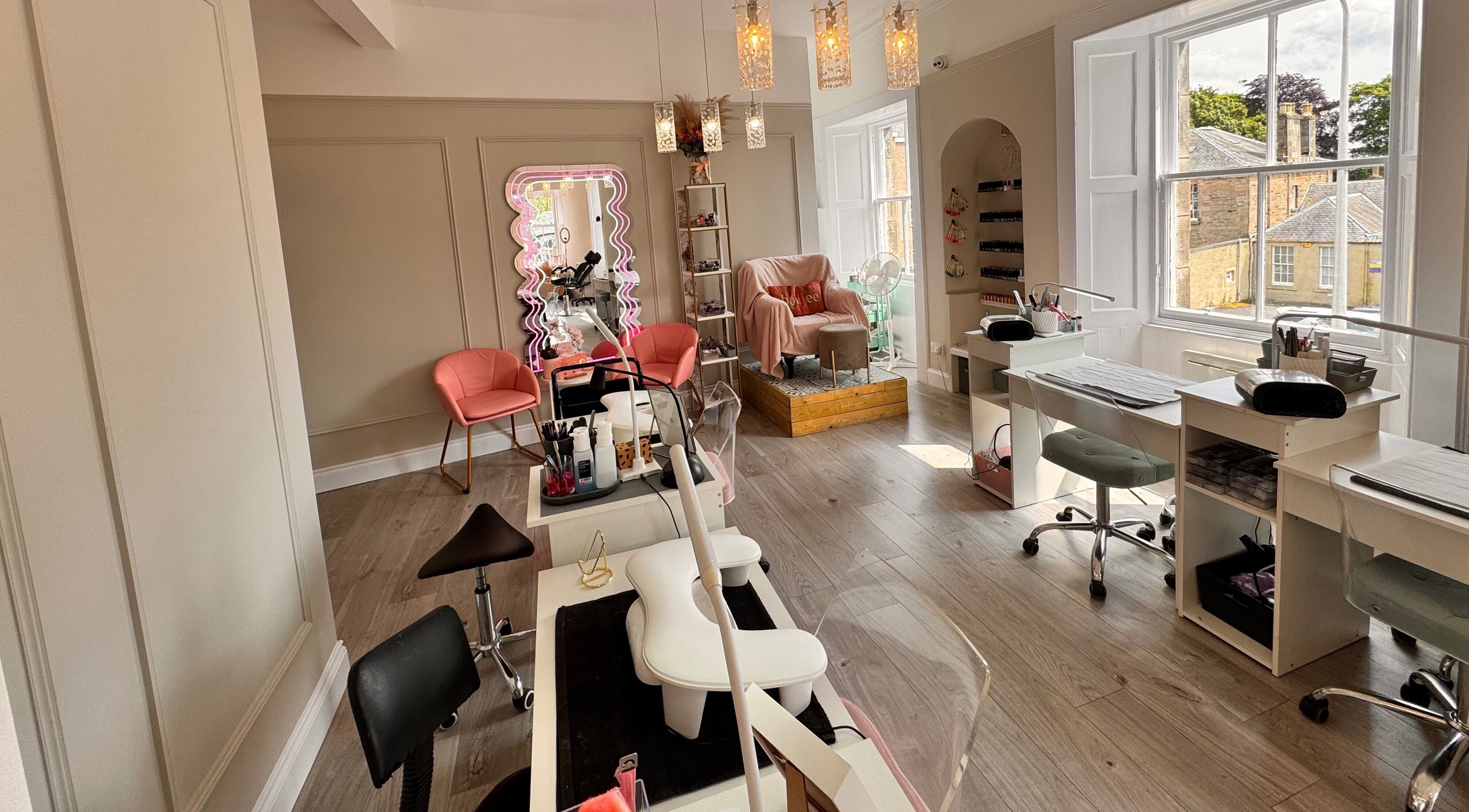 Spacious interior of Queens Beauty and Nails, Dunfermline, Scotland, GB featuring modern nail stations.