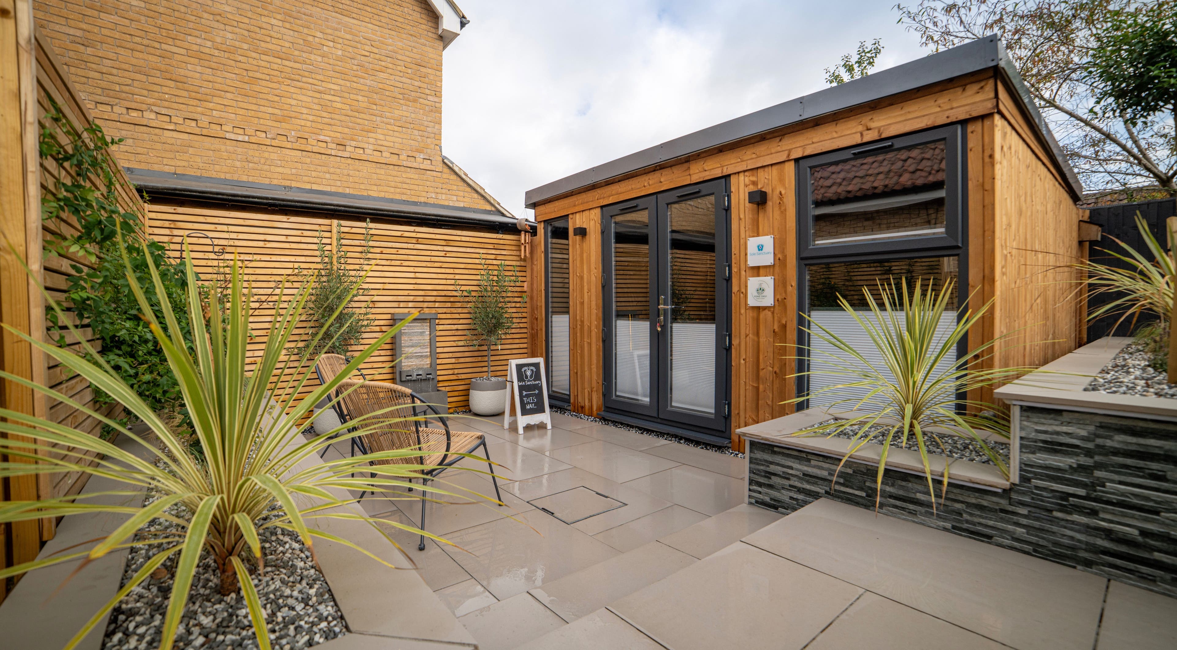Stylish outdoor entrance to Sole Sanctuary, Kennett, England, GB, featuring inviting patio with plants.