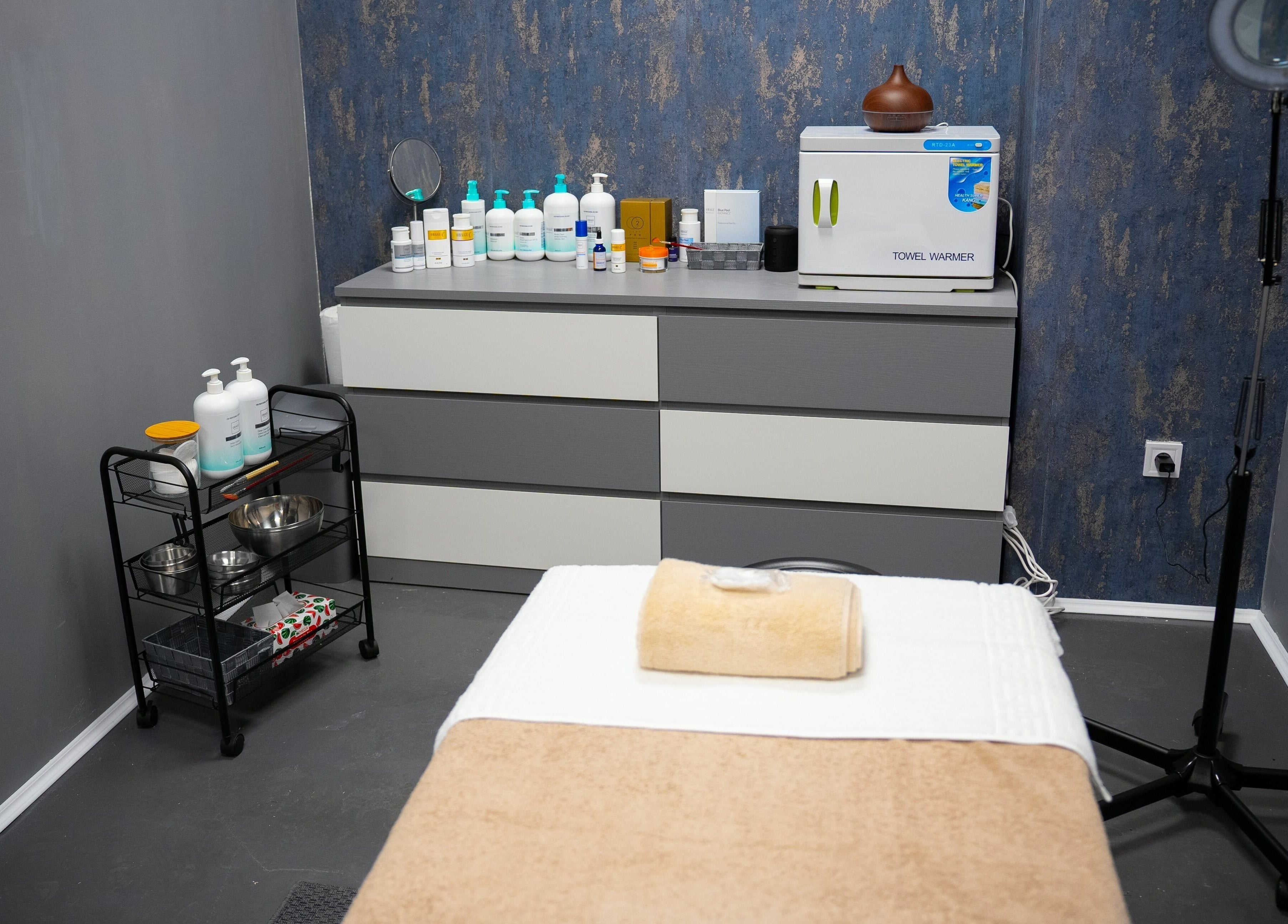 Camera de tratament spa la TheSpa, București, București, RO, cu masă de masaj și produse de îngrijire.