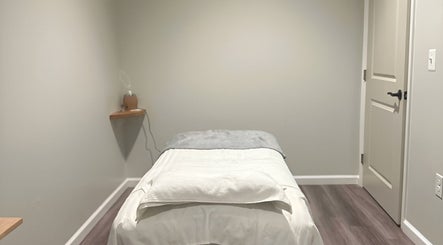 Cozy massage room at Gunston Massage in Lorton, Virginia, US, featuring a neatly arranged treatment bed.