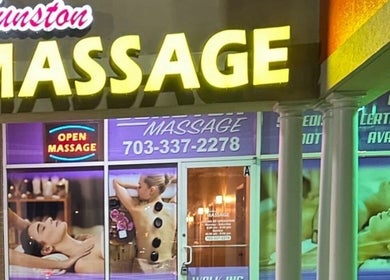 Gunston Massage storefront in Lorton, Virginia, US, displaying massage services and neon signs.