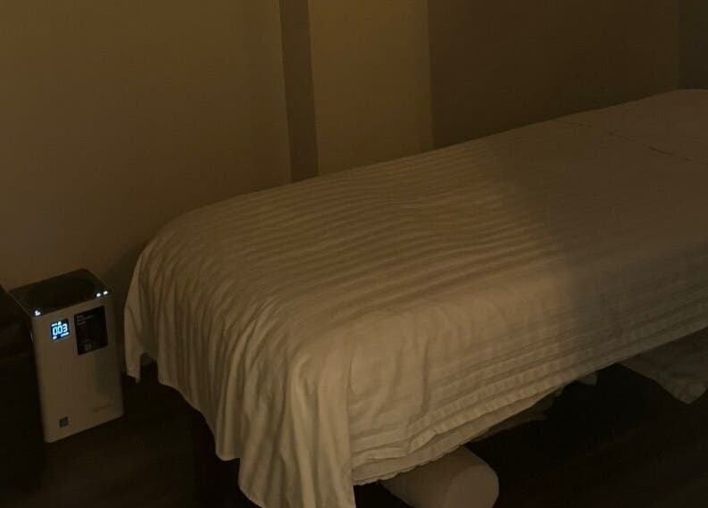 Cozy massage room at Gunston Massage in Lorton, Virginia, US, featuring a neatly made table and dim lighting.