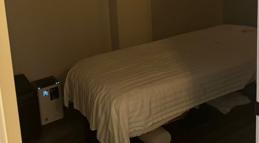 Cozy massage room at Gunston Massage in Lorton, Virginia, US, featuring a neatly made table and dim lighting.