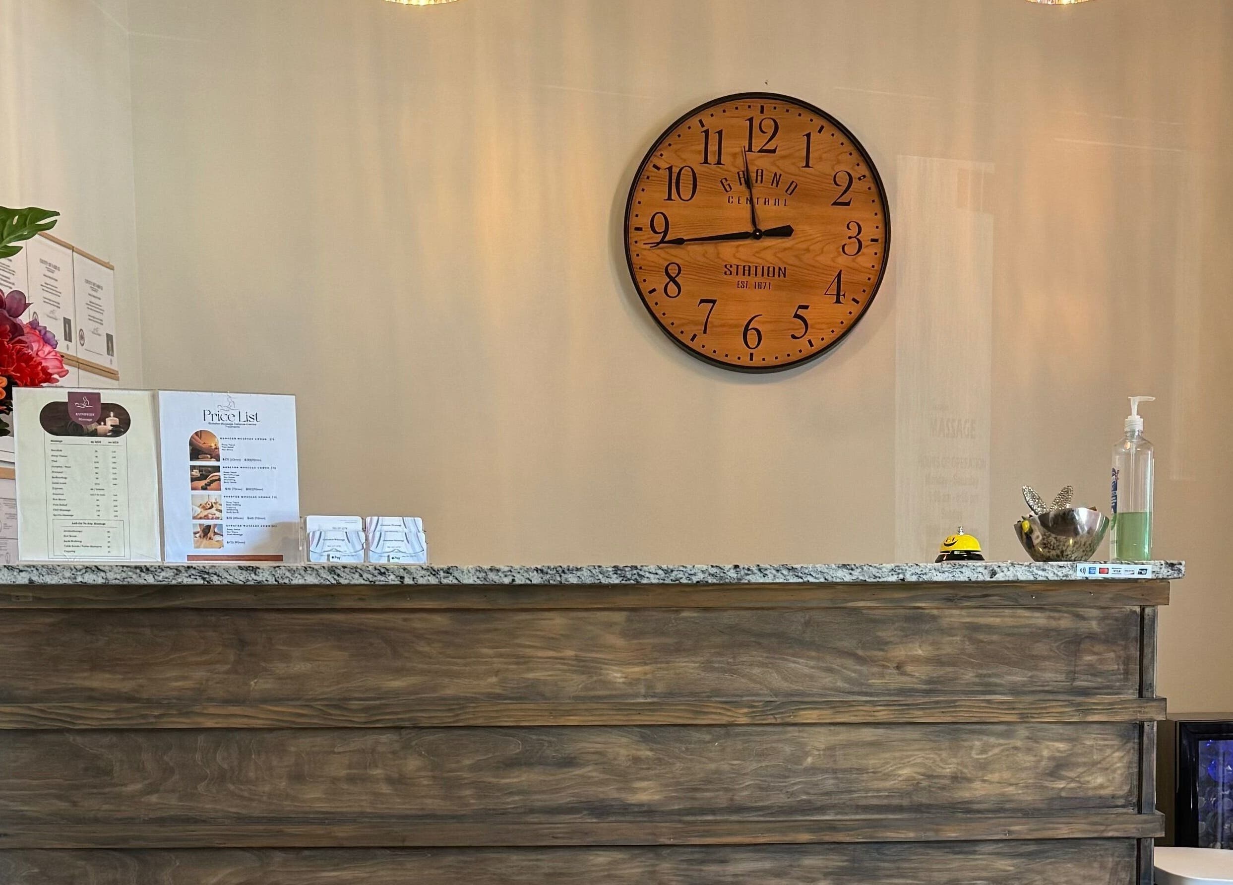 Reception area at Gunston Massage with flowers and clock, Lorton, Virginia, US.