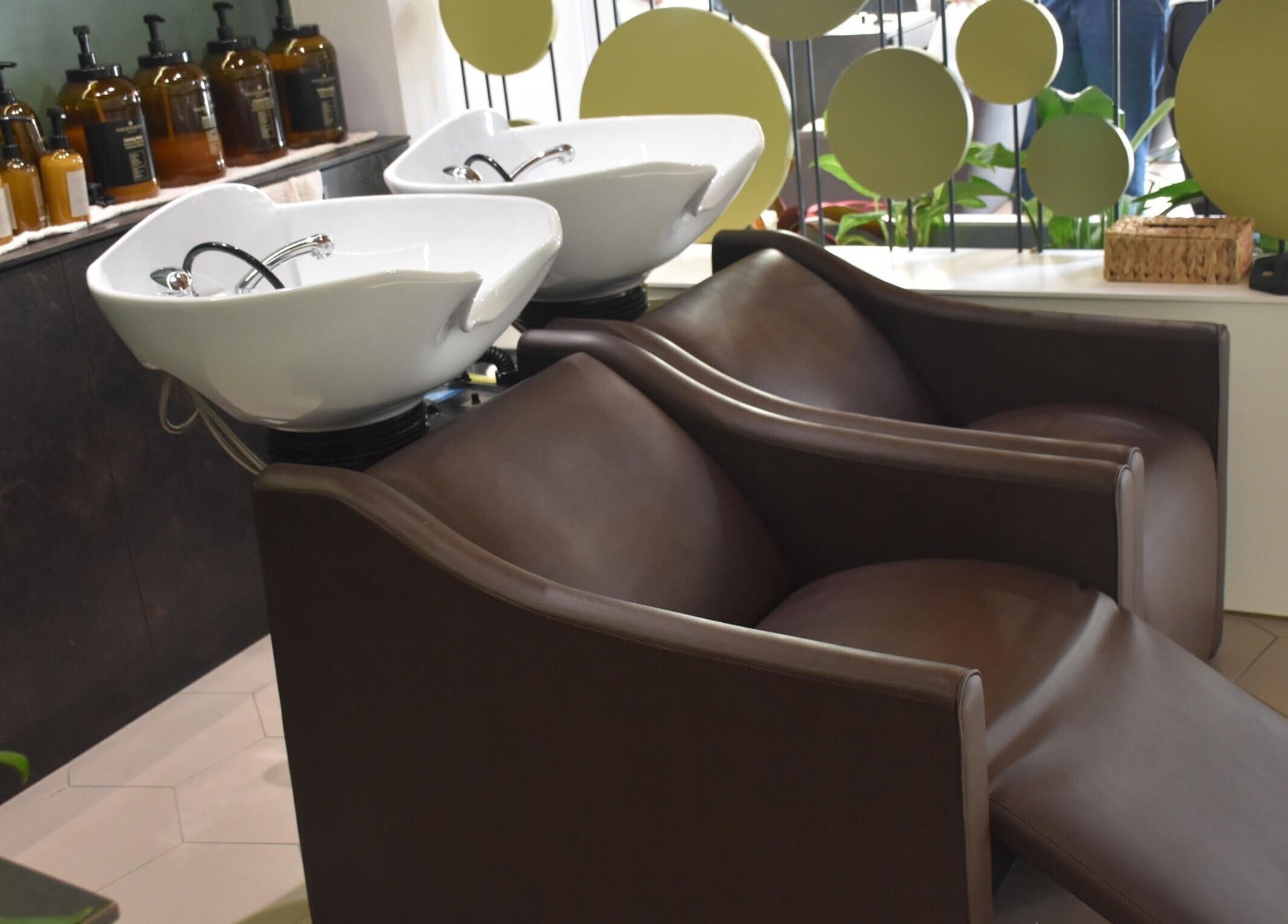 Area lavaggio moderna presso Salone Gala Rovigo, Rovigo, Veneto, IT, con poltrone marroni e lavabi bianchi.