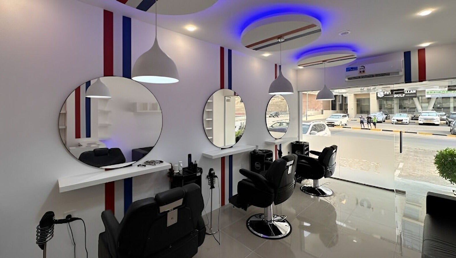 Chic salon interior at TOUCH UP - Wadi Kabir, Muscat, Oman showcasing modern black chairs and round mirrors.
