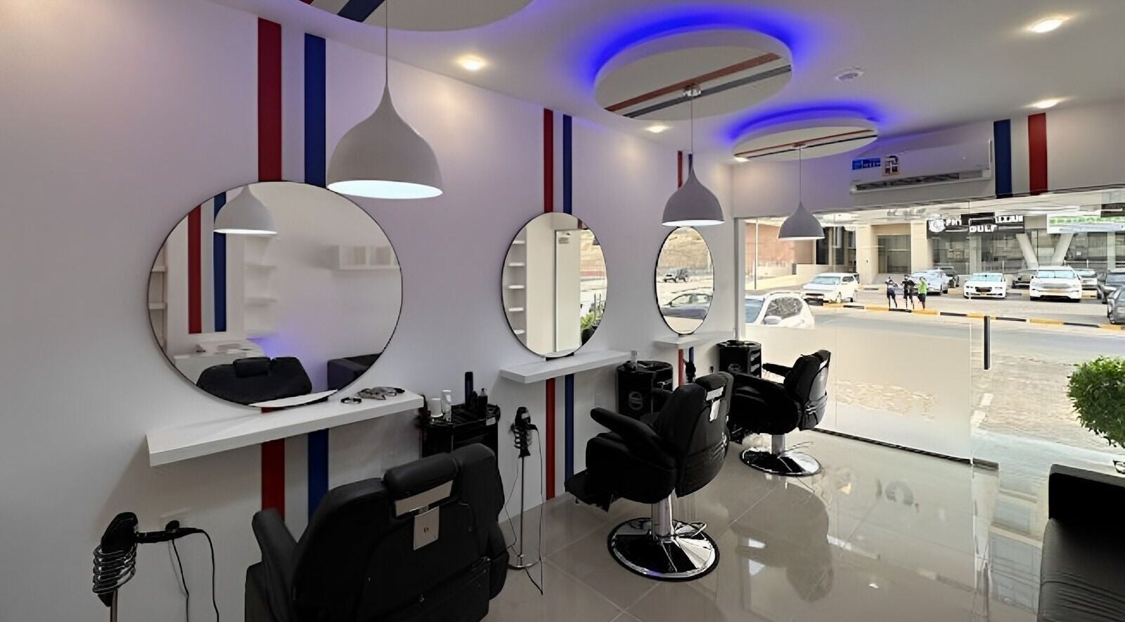 Chic salon interior at TOUCH UP - Wadi Kabir, Muscat, Oman showcasing modern black chairs and round mirrors.