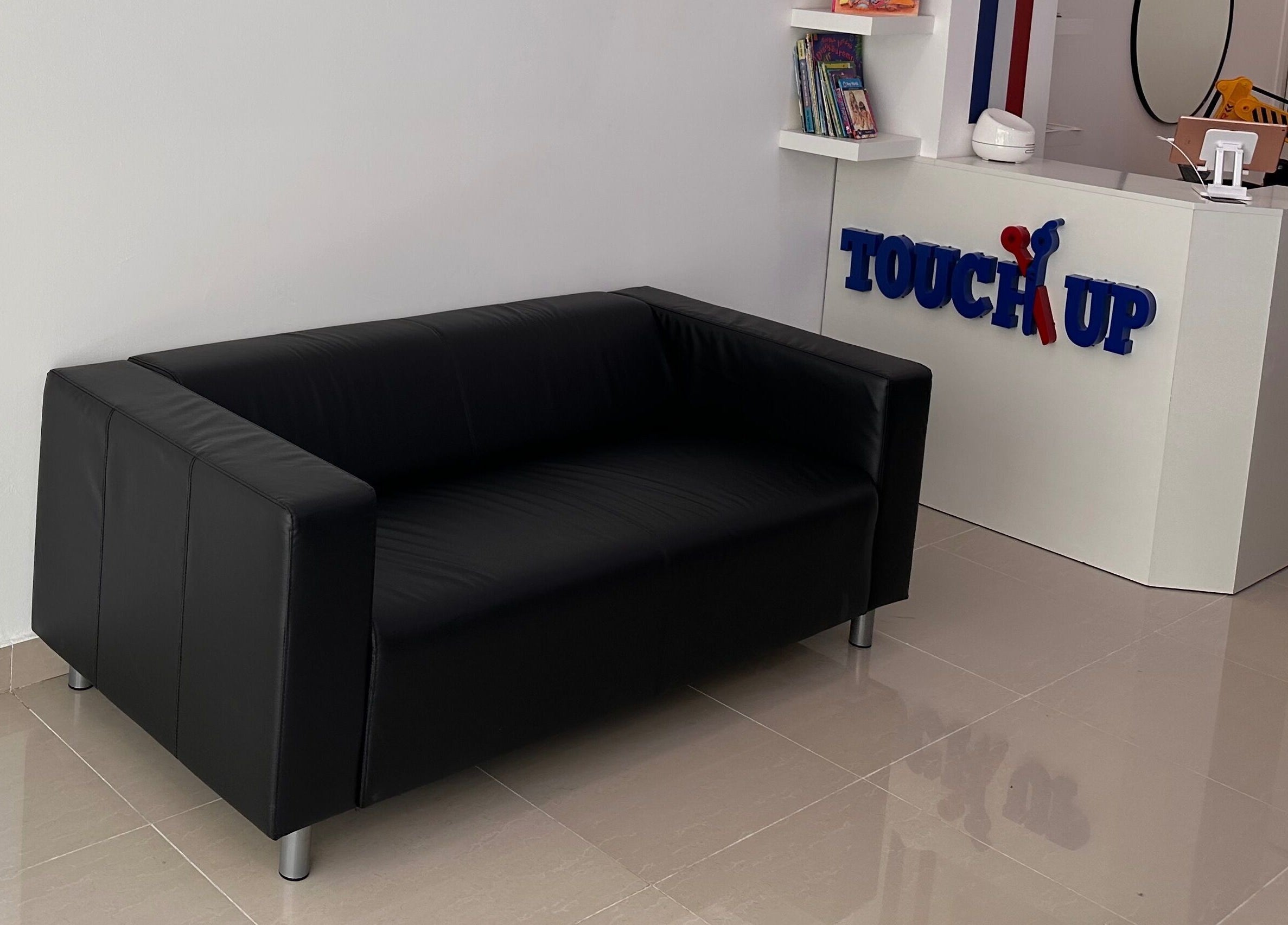 Relaxing reception area at TOUCH UP - Wadi Kabir, Muscat, Oman with a black sofa at Wadi Al Kabir, Muscat Governorate, OM.