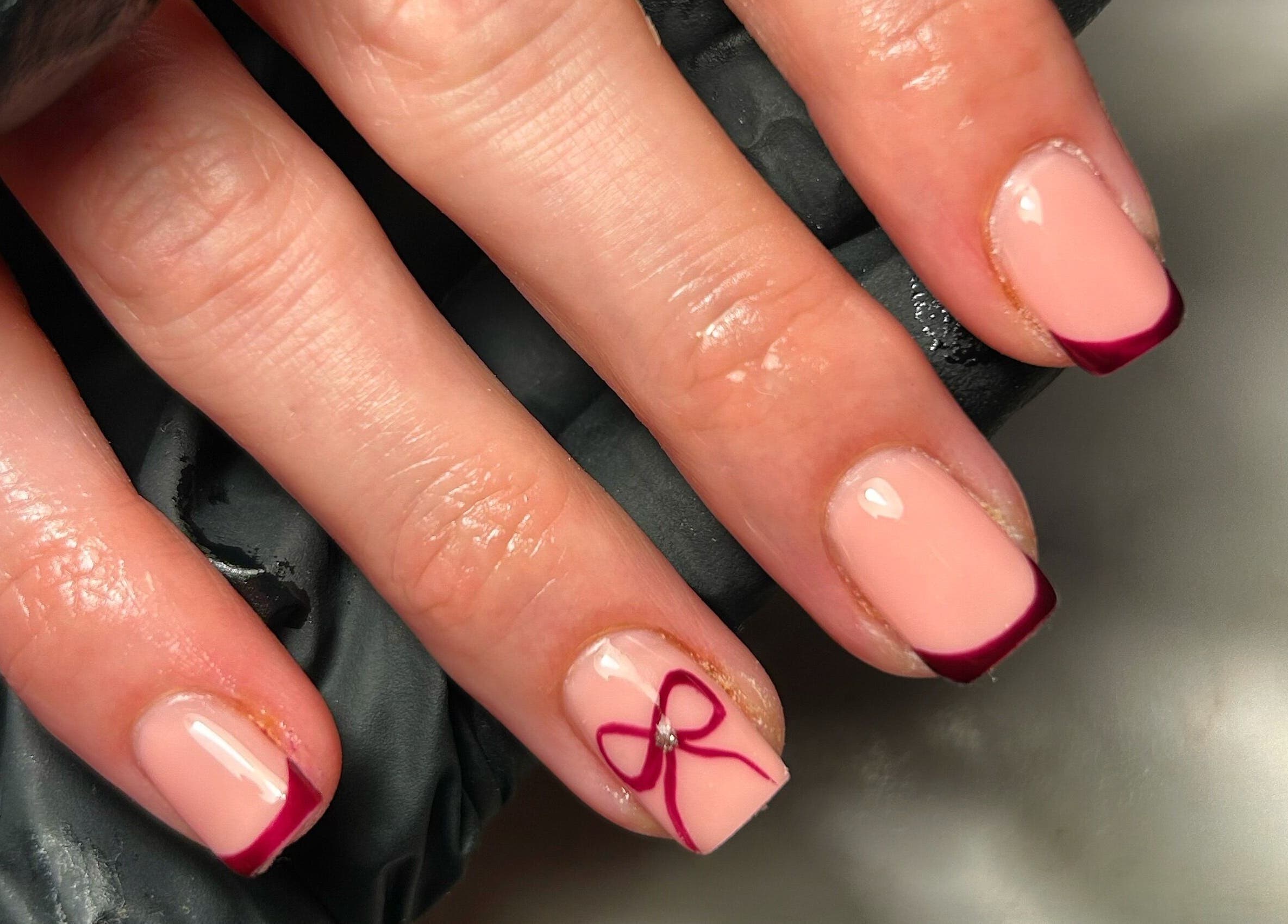 Stylish French manicure with bow design at The Beauty Q, Feering, England, GB.